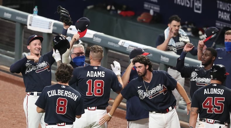 072120 Atlanta: Atlanta Braves Matt Adams is congratulated by teammates hitting a walk off home run for a 10-9 victory over the Miami Marlins during the ninth inning in an exhibition game on Tuesday, July 21, 2020 in Atlanta. Curtis Compton ccompton@ajc.com