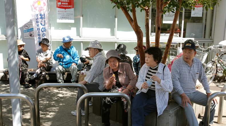 Elderly people rest under the shade of a tree in Tokyo, Sunday, Sept. 14, 2014. (AP Photo/Shizuo Kambayashi, File)