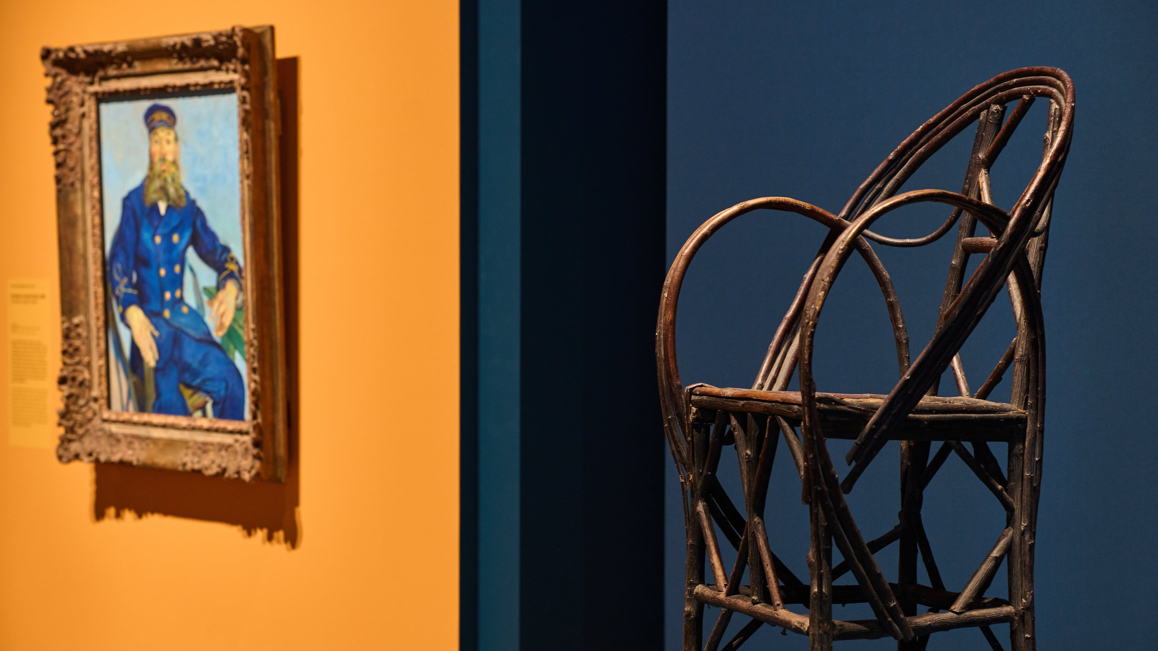 The chair in which bearded postman Joseph Roulin sat when he was portrayed by Vincent Van Gogh is displayed next to Roulin's portrait at the Van Gogh Museum in Amsterdam, Netherlands, Wednesday, Oct. 1, 2025. (AP Photo/Peter Dejong)