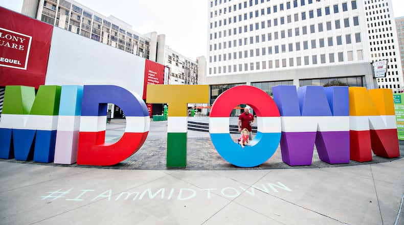 The MIDTOWN letters showed up outside Colony Square just in time for St. Patrick's Day. Kathryn Rudder climbs through the letter O in Midtown at Colony Square Mall in Atlanta as she and her father Robert wait for the start of the annual St. Patrick's Day Parade on Saturday, March 12, 2016. JONATHAN PHILLIPS / SPECIAL