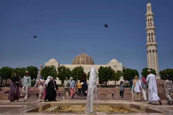 Tourists walk through the courtyard of the Sultan Qaboos Grand Mosque in Muscat, Oman, Saturday, April 12, 2025. (AP Photo/ Fatima Shbair)