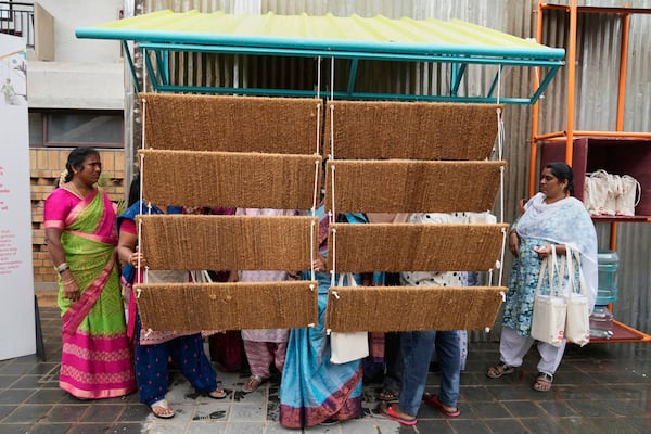Daily wage workers, who mostly work outdoors, explore Neralu, an innovative portable heat shelter, at the Sweat and Concrete 2025 event in Bengaluru, India, Thursday, May 29, 2025. (AP Photo/Aijaz Rahi)