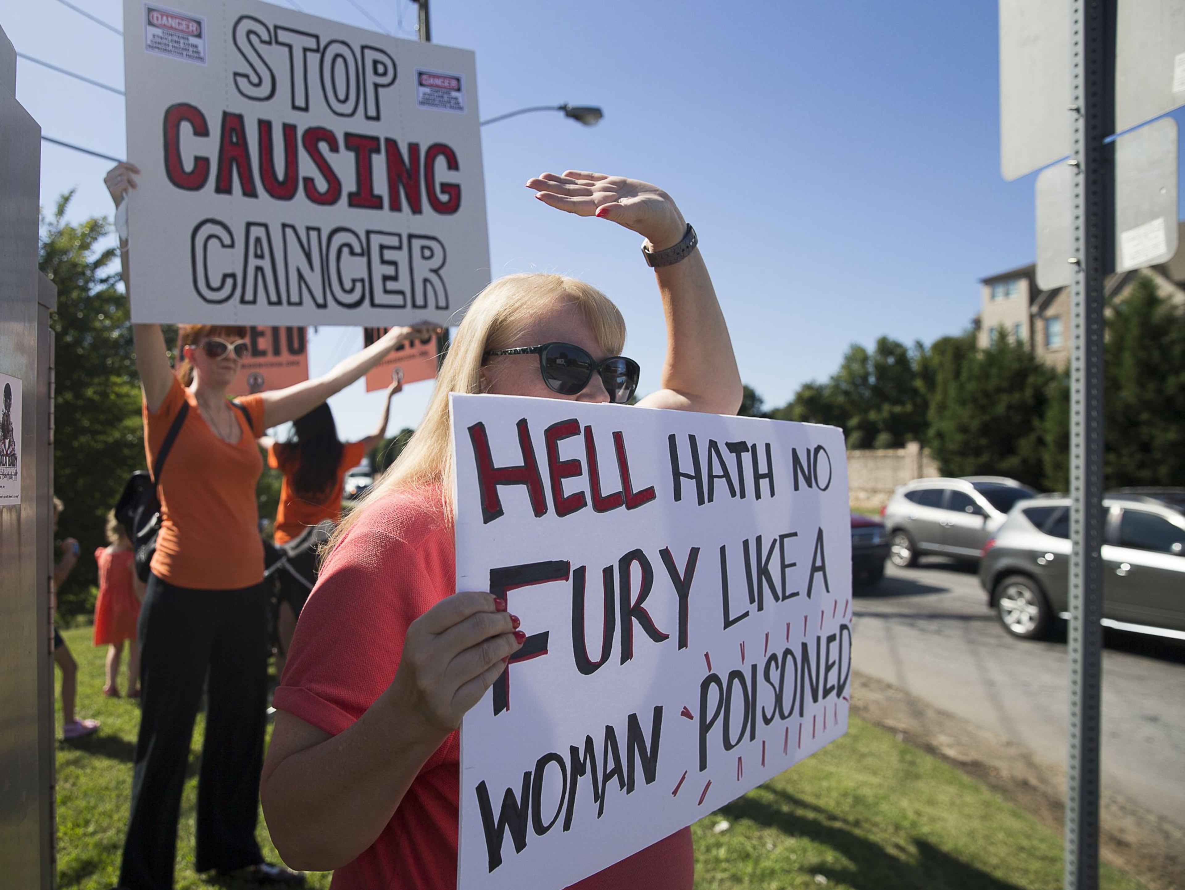 Jenni Shover of Smyrna (center) holds a sign during a protest against the Cobb County Sterigenics plant at the intersection of Atlanta Road and Plant Atkinson Road. (Alyssa Pointer/AJC 2019)