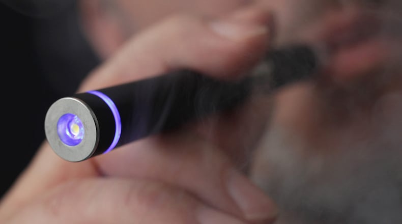 In this photo illustration, the owner of a shop that sells electronic cigarettes demonstrates how to use one on March 1, 2012, in Berlin, Germany. (Getty Images)
