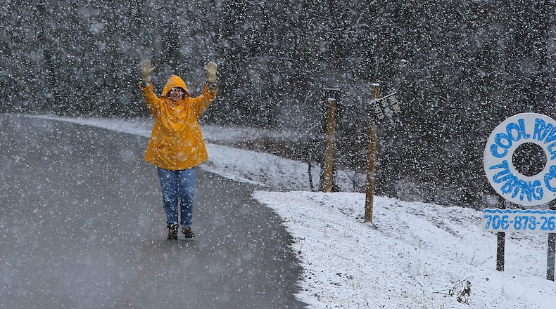 Local resident Linda Thomason plays in the heavy snow fall while taking a walk on Popular Stump Road near her home on Tuesday, Feb. 11, 2014, in Helen. CURTIS COMPTON / CCOMPTON@AJC.COM