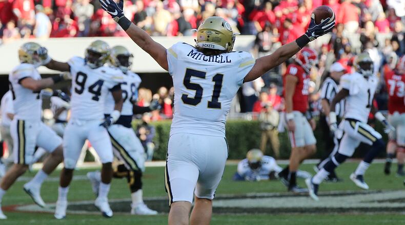 Georgia quarterback Jacob Eason walks off the field as Georgia Tech linebacker Brant Mitchell intercepts his pass and starts the celebration on the final play of the game for a 28-27 victory over Georgia in a NCAA college football rivalry game on Saturday, Nov. 26, 2016, in Athens. Curtis Compton/ccompton@ajc.com