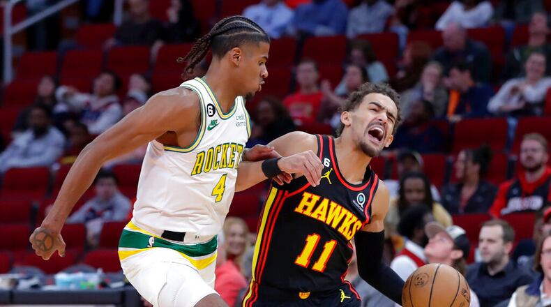 Atlanta Hawks guard Trae Young (11) reacts as he drives around Houston Rockets guard Jalen Green (4) during the first half of an NBA basketball game Friday, Nov. 25, 2022, in Houston. (AP Photo/Michael Wyke)