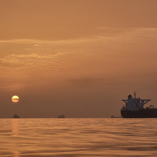 The sun rises behind tankers anchored in the Strait of Hormuz off the coast of Qeshm Island, Iran, Saturday, April 18, 2026. (AP Photo/Asghar Besharati)