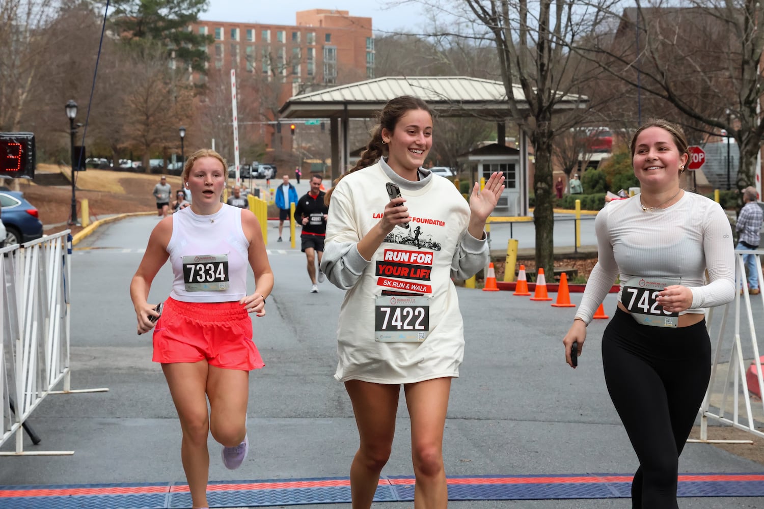 Runners cross the finish line on Saturday, Feb. 21, 2026, at a 5K walk/run and memorial service at UGA for Augusta University nursing student Laken Riley. Riley was attacked on Feb. 22, 2024 while running in Oconee Forest Park on the UGA campus and killed. Riley had previously attended UGA and was an avid runner. (C.J. Bartunek for the AJC)
