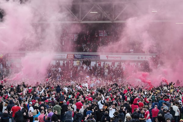 Wrexham players celebrate with fans as they win the English League One soccer match between Wrexham and Charlton Athletic at the Racecourse ground in Wrexham, Wales, Saturday, April 26, 2025. (AP Photo/Jon Super)
