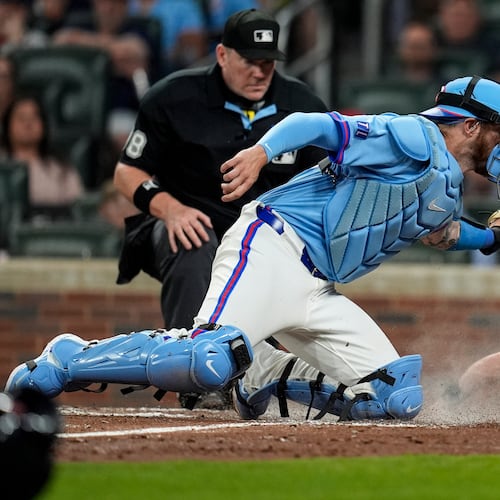 Cleveland Guardians' Daniel Schneemann (10) is safe at home plate against Atlanta Braves catcher Jonah Heim (20) inning of a baseball game, Saturday, April 11, 2026, in Atlanta. (AP Photo/Mike Stewart)
