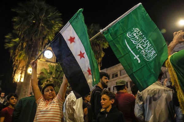 Syrians celebrate after U.S. President Donald Trump announced plans to ease sanctions on Syria and move toward normalizing relations with its new government to give the country 'a chance at peace,' in Idlib, Syria, Tuesday, May 13, 2025. (AP Photo/Ghaith Alsayed)