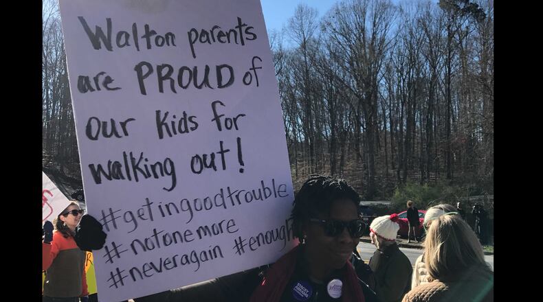More than 260 Walton High School students walked out of school last week as part of a nationwide protest against gun violence. Dozens of parents and community members stood outside the school with signs to show their support.  Vanessa McCray/AJC