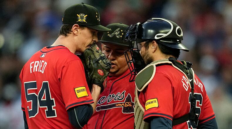 Atlanta Braves' Max Fried (54) speaks with bullpen coach Erick Abreu, center, and catcher Travis d'Arnaud (16) on the mound in the third inning of a baseball game against the San Diego Padres, Friday, May 17, 2024, in Atlanta. (AP Photo/Mike Stewart)