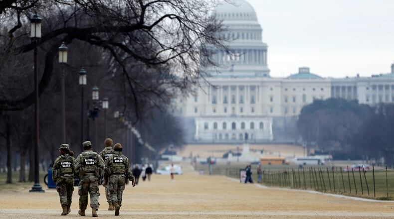 National Guard patrol the Washington Mall, with the U.S. Capitol in the background, Friday, Jan. 9, 2026, in Washington. (AP Photo/Rahmat Gul)