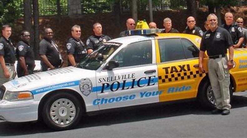 Snellville Councilmember Bobby Howard with Snellville Police Officers and the city’s Cop Cab, designed to increase awareness of the consequences of driving under the influence of drugs and alcohol. Courtesy City of Snellville