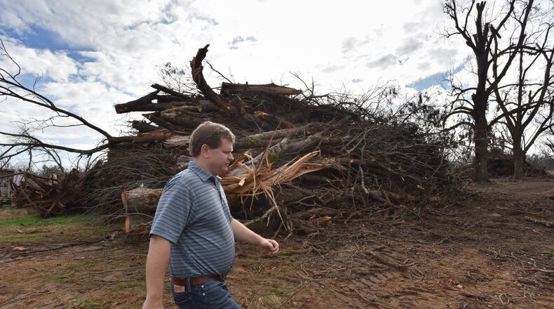 South Georgia pecan farmer Trey Pippin walks past a pile of dead pecan trees at his farm in Albany in 2019. South Georgia farmers will get some federal disaster relief aid for the estimated $2.5 billion in losses from Hurricane Michael. HYOSUB SHIN / HSHIN@AJC.COM