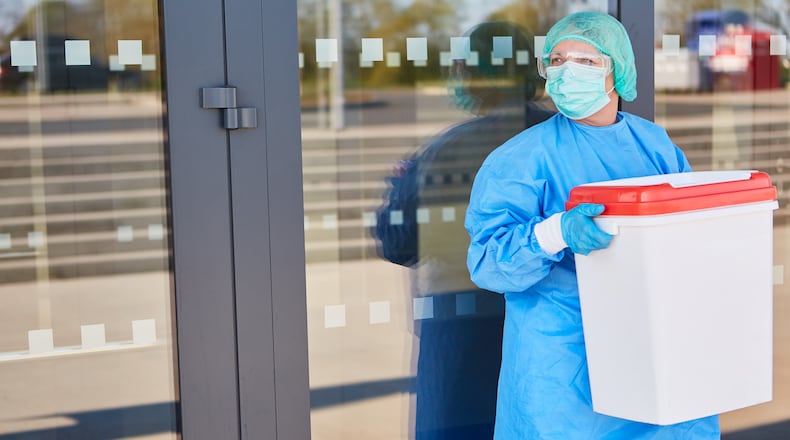 A healthcare worker carries organ for donation in a cooler. (Robert Kneschke/Dreamstime/TNS)