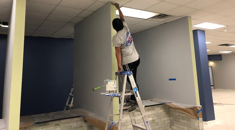 A worker paints trim at Clayton County’s renovated health department, which will reopen to the public in May after closing in February 2018 because of mold and water damage. PHOTO: LEON STAFFORD