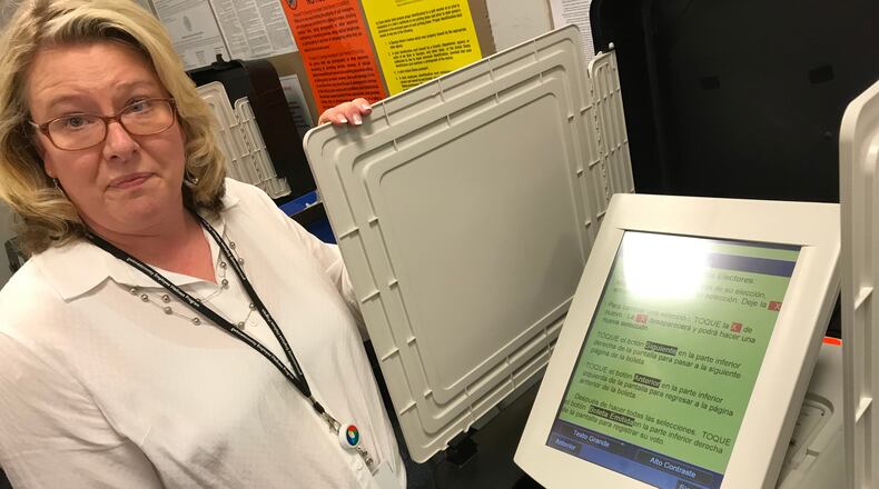 Gwinnett elections director Lynn Ledford shows off a voting machine's Spanish-language ballot. TYLER ESTEP / TYLER.ESTEP@AJC.COM