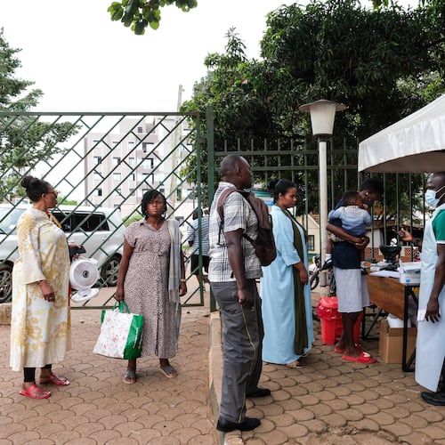People wait to have their temperature taken in front of Kibuli Muslim Hospital in Kampala, Uganda, Saturday, May 16, 2026. (AP Photo/ Hajarah Nalwadda)