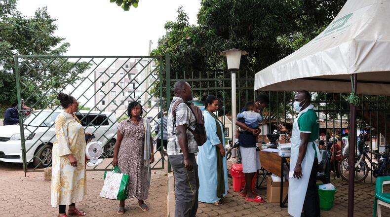 People wait to have their temperature taken in front of Kibuli Muslim Hospital in Kampala, Uganda, Saturday, May 16, 2026. (AP Photo/ Hajarah Nalwadda)