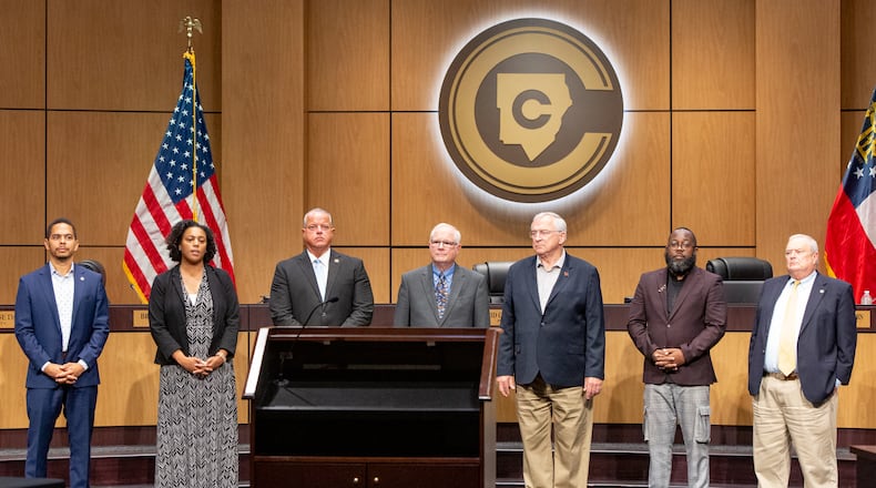 The Cobb County School District intends to continue intervening in a lawsuit between voting rights groups and the Cobb County Board of Elections. The former Cobb school board, most of which is pictured here, endorsed district maps for school board races that the voting rights groups say discriminate against people of color. Two of the board's former Democrats, Jaha Howard and Charisse Davis, at left, did not seek reelection in 2022, which was the first year the maps were used. (Jenni Girtman for The Atlanta Journal-Constitution)
