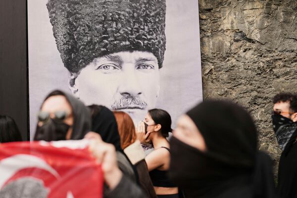 University students march past a photograph of Turkey's founder Mustafa Kemal Ataturk in Istanbul, Turkey, Thursday, March 27, 2025, during a protest after Istanbul's Mayor Ekrem Imamoglu was arrested and sent to prison. (AP Photo/Francisco Seco)
