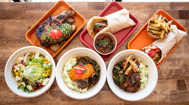 Selections from Karv Kitchen include (top row, from left) Half Rotisserie Chicken, Horta Wrap, Greko Wrap, (bottom row, from left) Corn Avocado Salad, Braised Collard Bowl, and Veggie Collard Bowl. Mia Yakel for The AJC