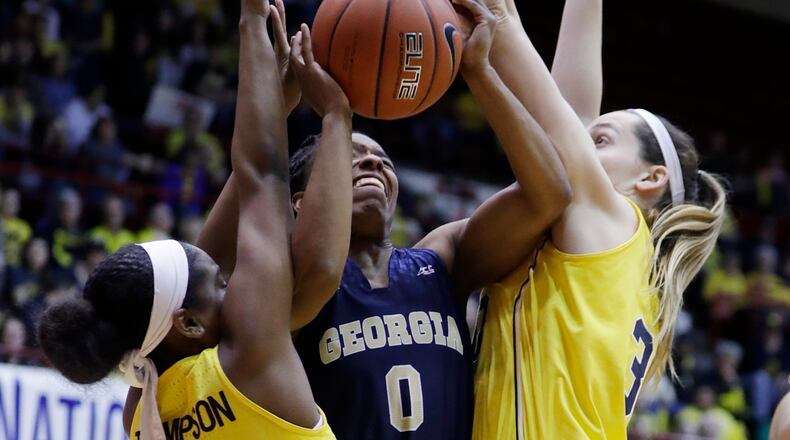 Georgia Tech guard Imani Tilford (0) attempts a shot defended by Michigan guard Siera Thompson (2) and center Hallie Thome (30) during the first half of the WNIT Championship college basketball game, Saturday, April 1, 2017, in Detroit. (AP Photo/Carlos Osorio)