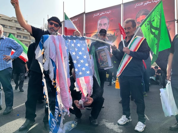People burn a U.S. flag as they take part in a funeral ceremony of Iranian army generals, nuclear scientists and their family members who were killed in Israeli strikes, in Tehran, Iran, Saturday, June 28, 2025. (AP Photo/Vahid Salemi)