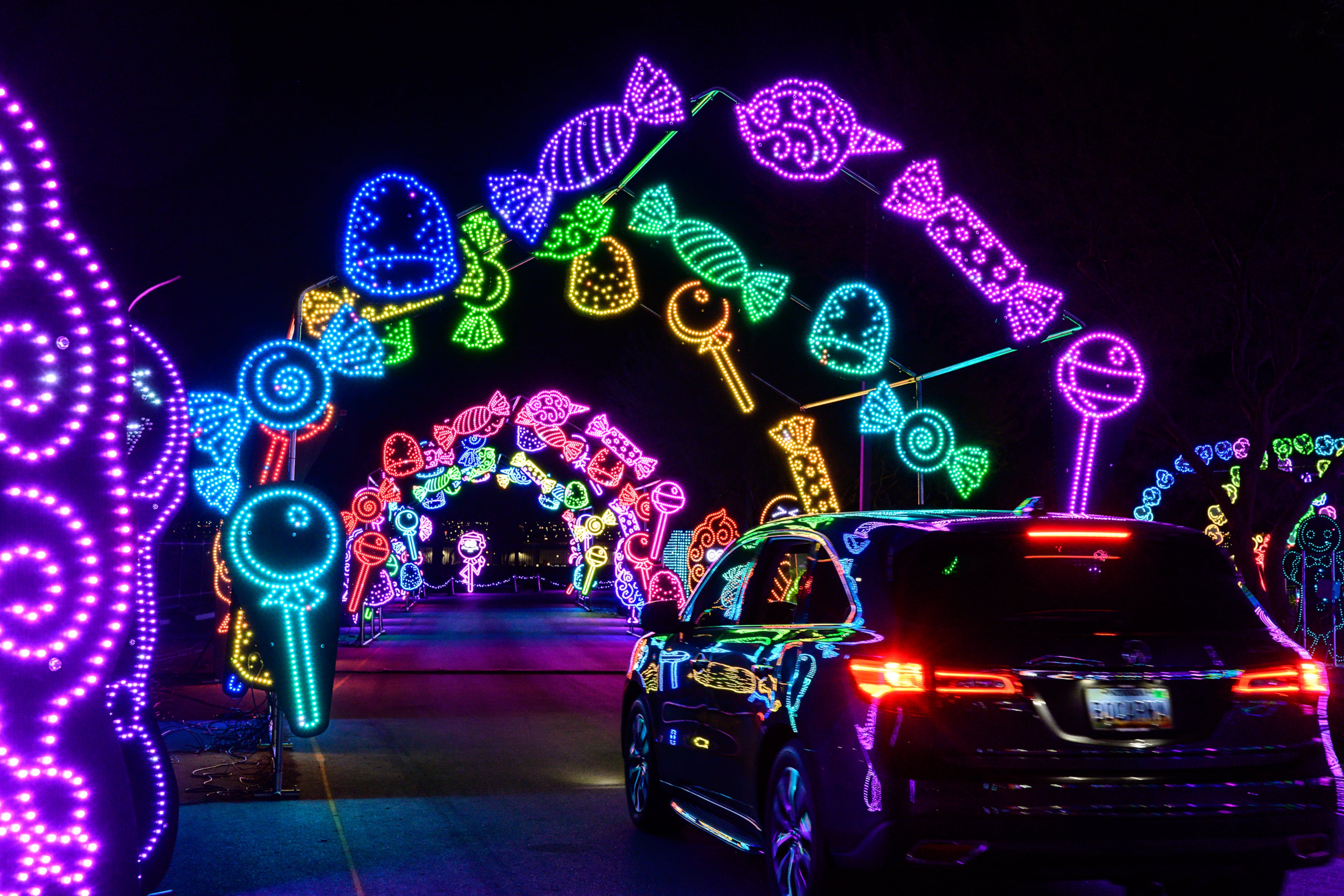 A car drives though World of Illumination's Candy Rush drive-through light show in 2024. This year the event will run through Jan. 4 at Six Flags White Water in Marietta. (courtesy of Tim Peluso 2024)