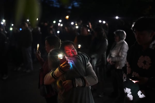 Liza Ahyeng, center right, hugs another attendee at a vigil for victims after a vehicle drove into a crowd during a Filipino heritage festival in Vancouver, British Columbia, Sunday, April 27, 2025. (AP Photo/Lindsey Wasson)