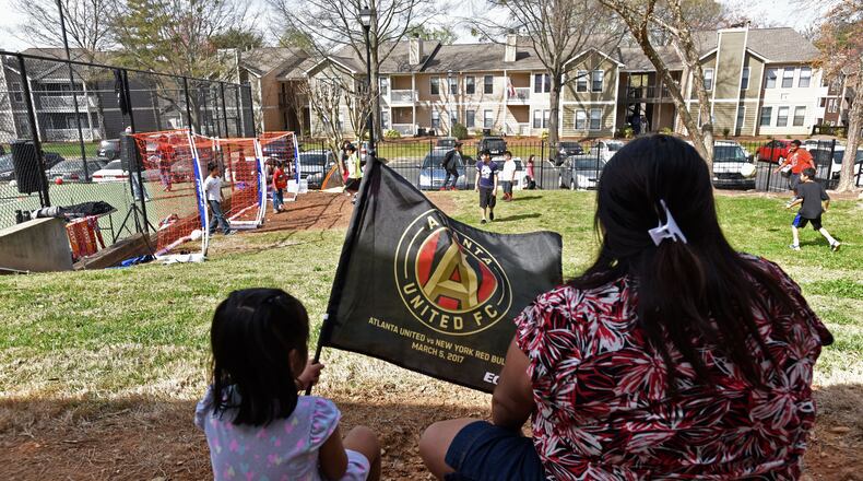 Community members participate in a soccer event hosted by YELLS (Youth Empowerment through Learning, Leading, and Serving, Inc.) to promote community engagement on Franklin Gateway at The Gallery apartment complex on Saturday, March 25, 2017. One of the boldest and most aggressive revitalization efforts in the metro Atlanta region will celebrate a major milestone later this year with the opening of Atlanta United’s $60 million soccer complex on Franklin Gateway in Marietta. But the community has incurred losses as a result of the redevelopment. The new facilities are replacing four apartment buildings that were bought and razed by the city, displacing some residents. HYOSUB SHIN / HSHIN@AJC.COM
