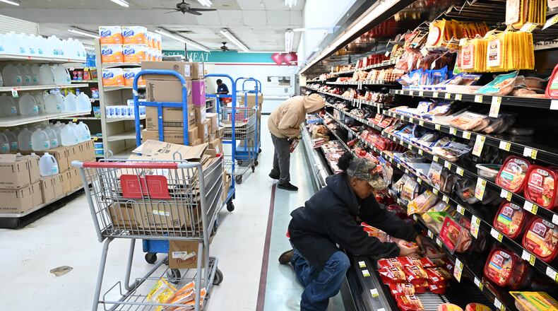 Peggy Harris (foreground) stocks the shelves at Sandy's IGA, which is the only grocery store in town, Tuesday, October 7, 2025, in Sparta. Hancock County has one of the highest rates of childhood food insecurity in the country. (Hyosub Shin/AJC)