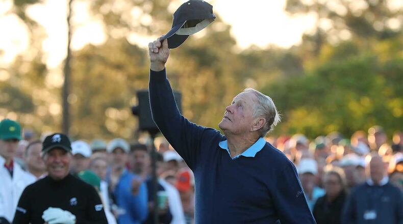 In a salute to the king of golf, Jack Nicklaus tips his hat toward heaven in honor of the late Arnold Palmer with Gary Player looking on while they hit their tee shots during the honorary start of the Masters at Augusta National Golf Club Thursday.