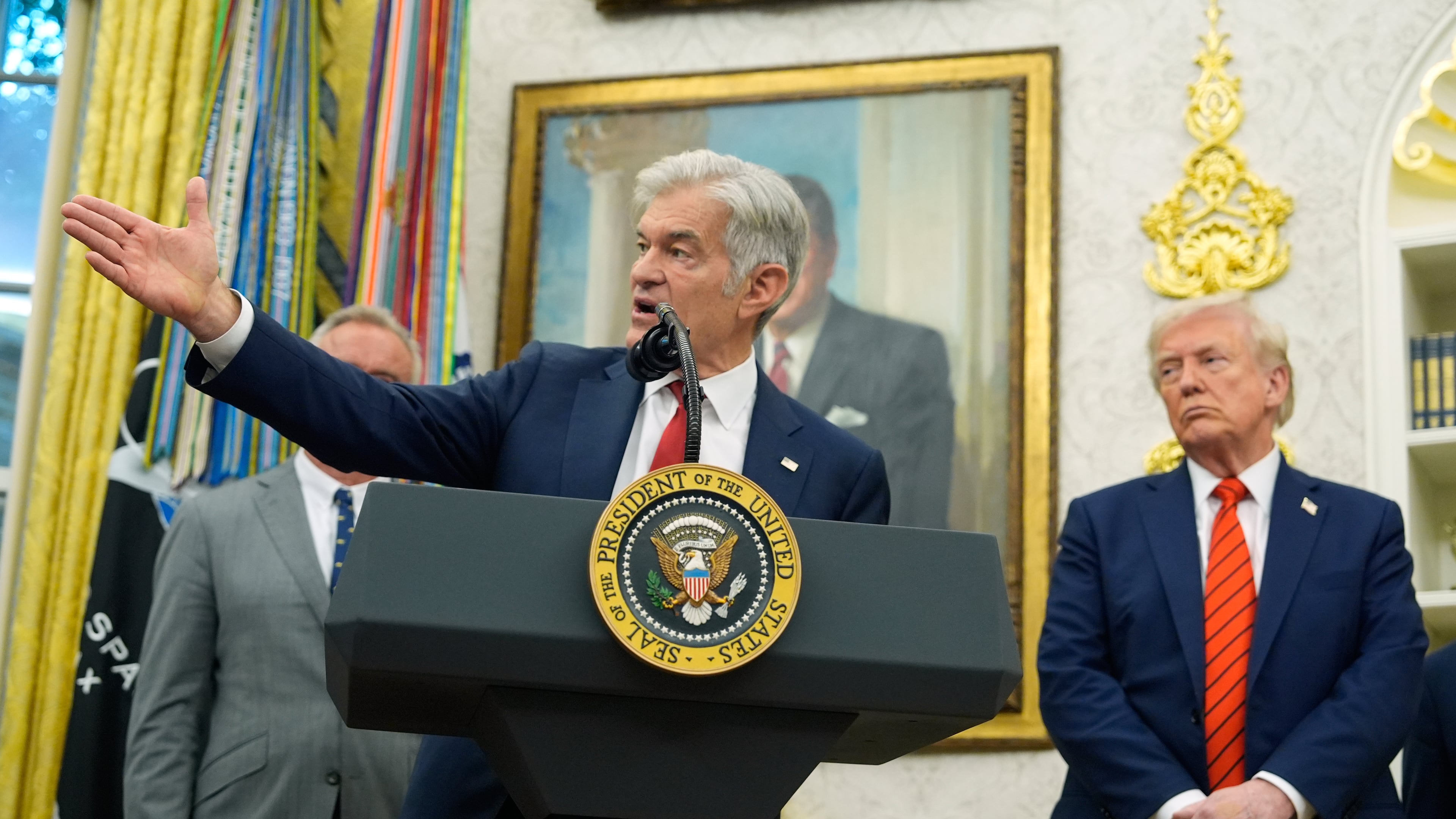 President Donald Trump listens as Centers for Medicare & Medicaid Services administrator Dr. Mehmet Oz speaks in the Oval Office of the White House, Friday, Oct. 10, 2025, in Washington. (AP Photo/Alex Brandon)