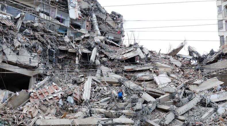 A man walks among the rubble of a building that collapsed in earthquakes the previous day in La Guaira, Venezuela, Thursday, June 25, 2026. (AP Photo/Pedro Mattey)