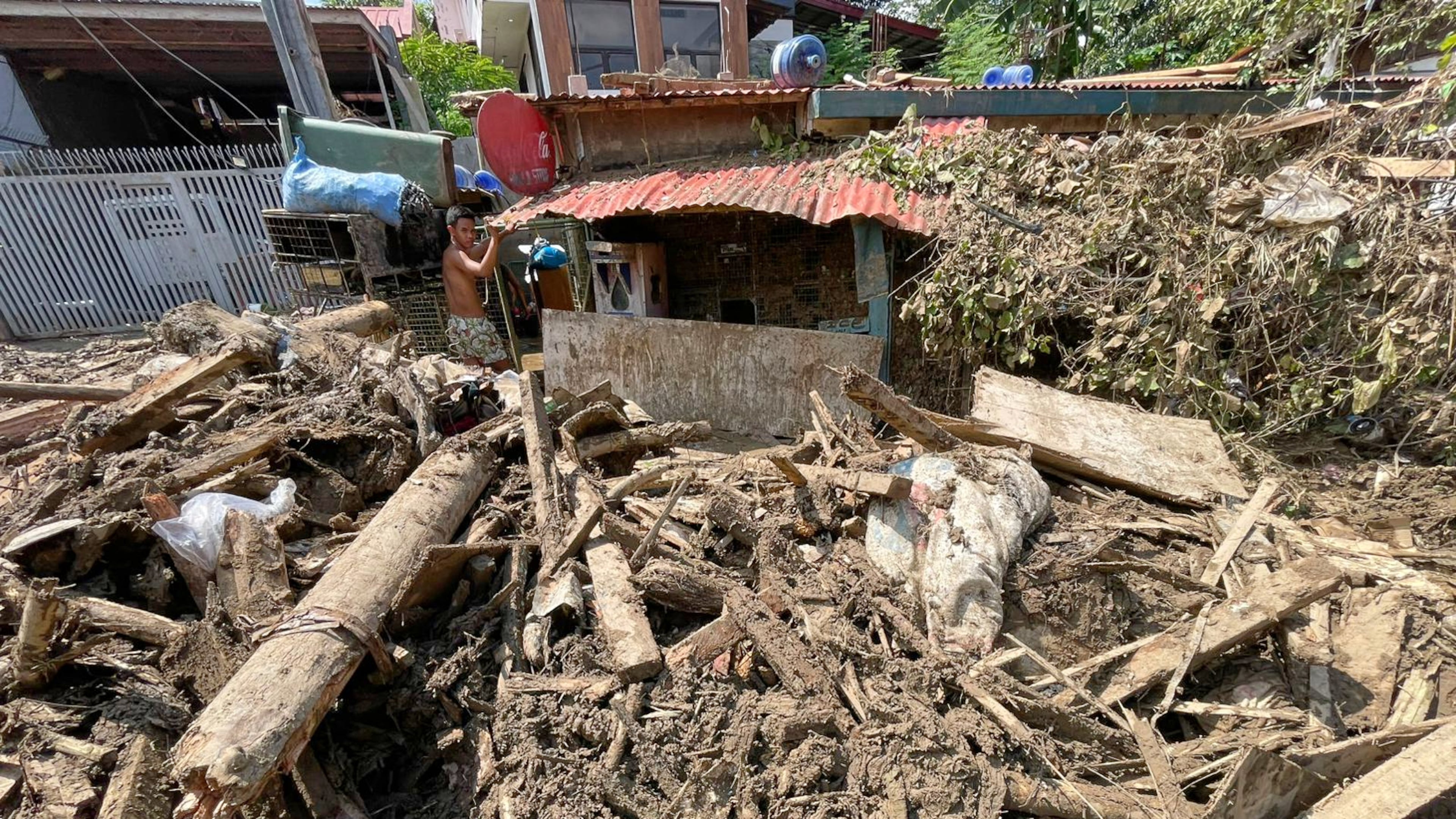 Debris lays outside a house as residents return to their flood damaged homes in Bacayan, Cebu province, central Philippines on Friday Nov. 7, 2025 after Typhoon Kalmaegi devastated the province and claimed lives. (AP Photo/Jacqueline Hernandez)