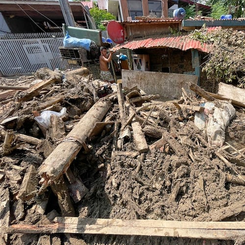 Debris lays outside a house as residents return to their flood damaged homes in Bacayan, Cebu province, central Philippines on Friday Nov. 7, 2025 after Typhoon Kalmaegi devastated the province and claimed lives. (AP Photo/Jacqueline Hernandez)