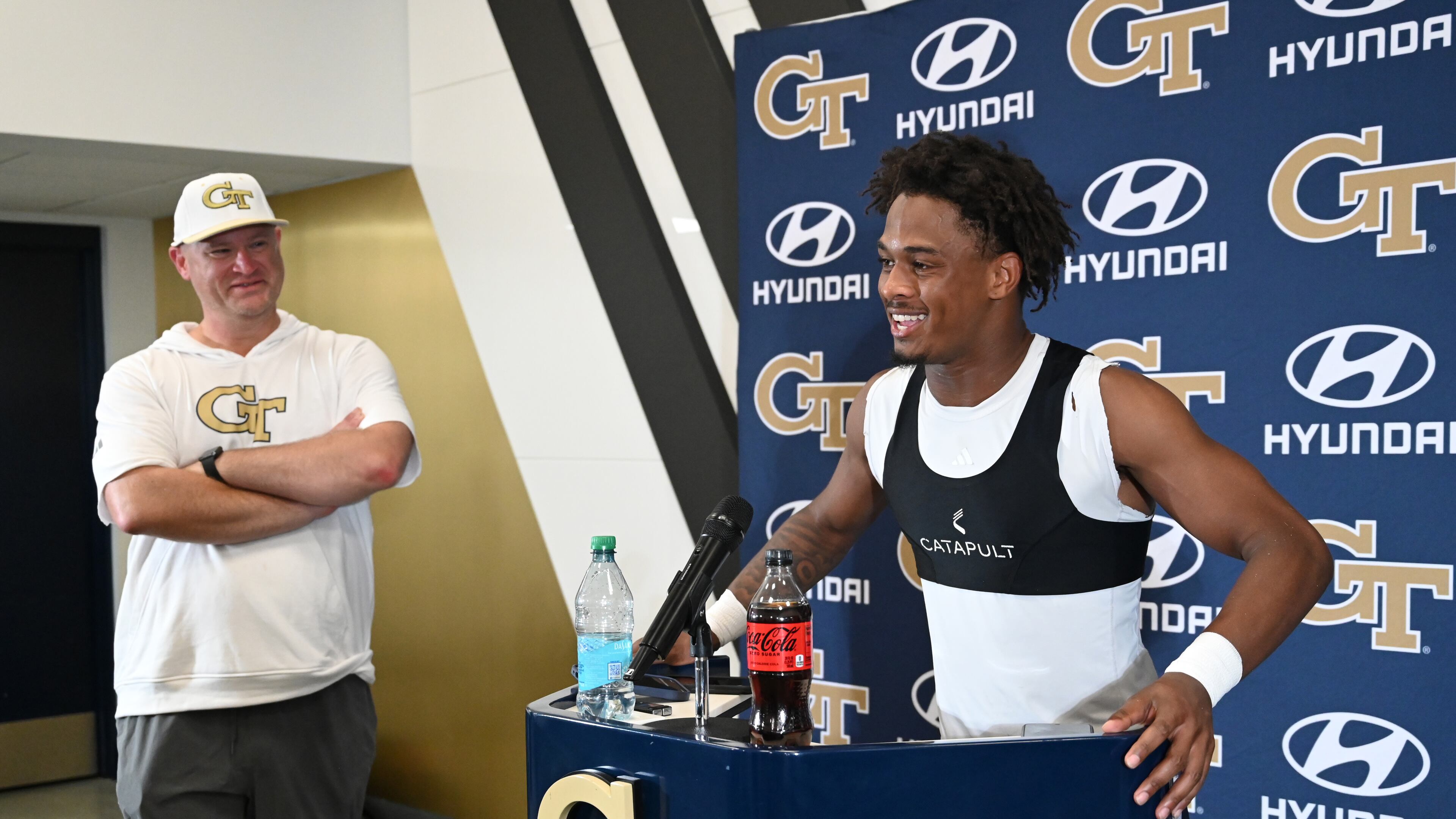 Tech defensive back Ahmari Harvey speaks to members of the press as head coach Brent Key looks on after their first day of football practice on Tuesday, July 29, 2025, in Atlanta. The Yellow Jackets are developing a game plan for Week 1 opponent Colorado. (Hyosub Shin/AJC)