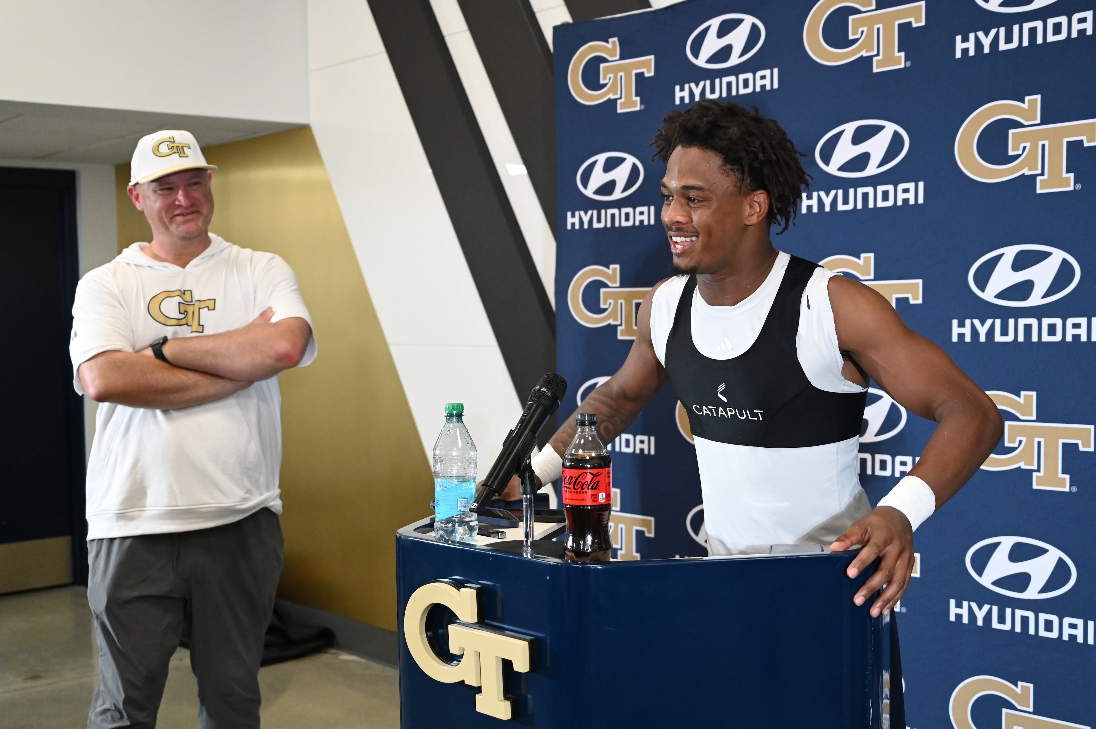 Georgia Tech defensive back Ahmari Harvey (3) speaks to members of the press as head coach Brent Key looks on after their first day of football practice, Tuesday, July 29, 2025, in Atlanta. (Hyosub Shin / AJC)