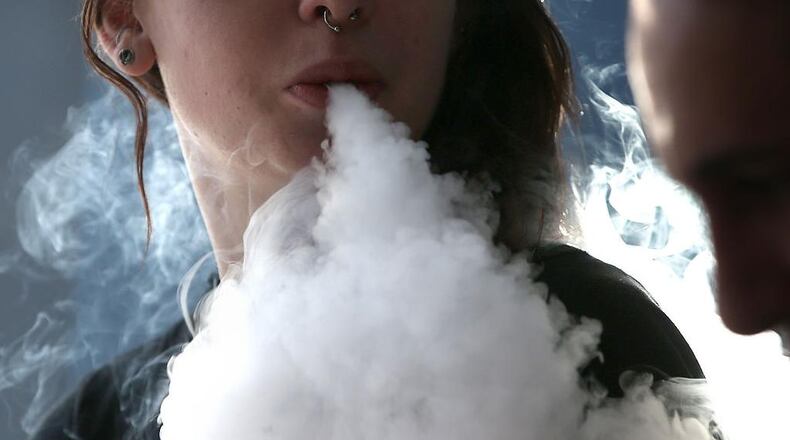 A girl smokes an e-cigarette. A new study recorded a dramatic uptick in the numbers of teenagers vaping nicotine in the past year. Experts are worried about the health affects.