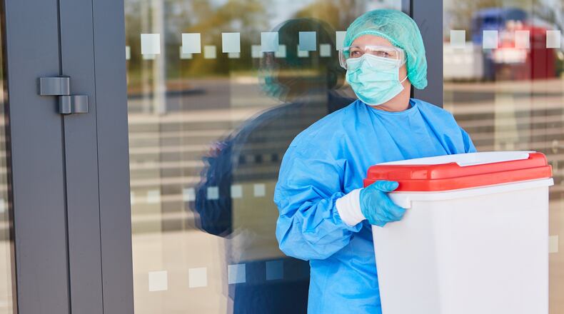 A healthcare worker carries organ for donation in a cooler. (Robert Kneschke/Dreamstime/TNS)