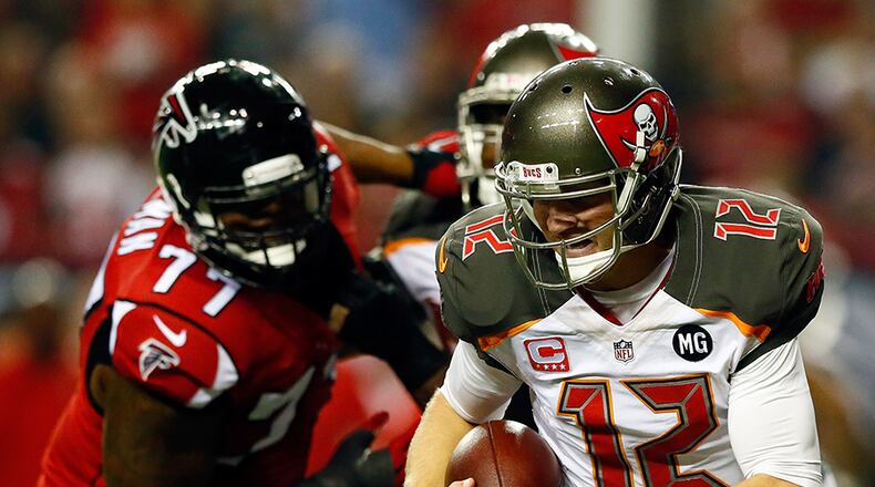 Falcons rookie defensive end Ra'Shede Hageman (background) forces Buccaneers quarterback Josh McCown to scramble under pressure in the Falcons' 56-14 win over Tampa Bay at the Georgia Dome in Atlanta.