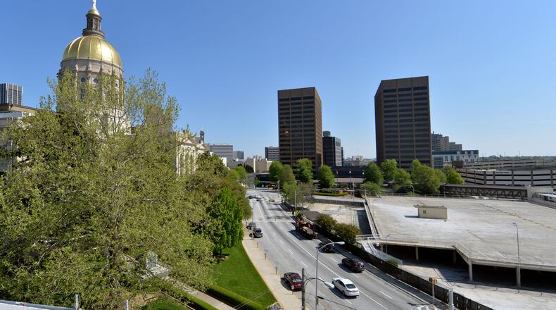 APRIL 17, 2014 ATLANTA The parking area at right will be transformed into Liberty Plaza, an area for protests and rallies. Liberty Plaza, which is scheduled to be open before the 2015 session, will be the first non-parking addition to the Capitol Hill since the Twin Towers were completed in 1980s. Photos showing the Georgia State Capitol, the old Department of Transportation building and the capitol parking deck, Thursday, April 17, 2014. Crews start demolishing a 60-year-old parking deck across from the statehouse this week, beginning what could be a years long project to give Capitol Hill it's first major facelift since the Jimmy Carter was president. The parking area will be transformed into Liberty Plaza, a protest-rally-park area that could become home to a planned new monument to MLK. Contractors will also rip up and rework the "front door" of the Capitol, the steps where racist editor and politician Tom Watson's statue stood until November, and renovate the old DOT building into office space. State officials are also talking of closing and/or rerouting traffic around the Capitol, and a new judicial complex and history center are being planned. Liberty Plaza, which is scheduled to be open before the 2015 session, will be the first, non-parking addition to the Capitol Hill since the Twin Towers were completed in 1980s. The changes will cost the state millions of dollars but supporters say it is a long time coming for an area that was once surrounded by factories and rail yards. KENT D. JOHNSON/KDJOHNSON@AJC.COM Which candidate for governor has the best vision for rebuilding Georgia schools? (KENT D. JOHNSON / AJC)