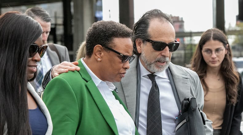 Rev Mitzi Bickers (green blazer) is found guilty on all but three charges at the Richard B Russell Federal Courthouse on Wednesday, March 23, 2022.  Bickers is surrounded by friends, family and her attorney Drew Findling (dark sunglasses) as she leaves the courthouse.  Sentencing is scheduled for July 12.  (Jenni Girtman for The Atlanta Journal-Constitution)