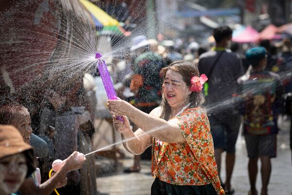 Woman play water during the Songkran water festival to celebrate the Thai New Year in Prachinburi Province, Thailand, Sunday, April 13, 2025. (AP Photo/Wason Wanichakorn)