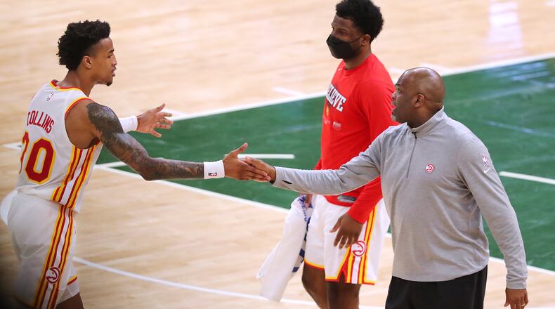 062321 Milwaukee: Atlanta Hawks forward John Collins gets five from interim head coach Nate McMillan after his three pointer against the Milwaukee Bucks in game 1 of the NBA Eastern Conference Finals at Fiserv Forum on Wednesday, June 23, 2021, in Milwaukee. “Curtis Compton / Curtis.Compton@ajc.com”