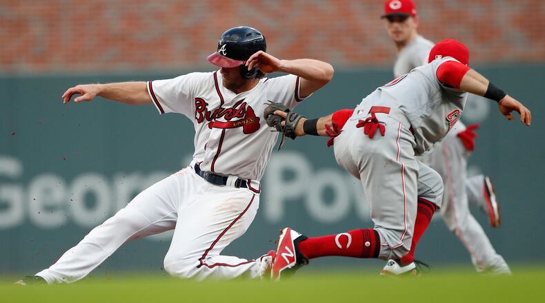 The Braves’ Charlie Culberson slides past the tag of Reds shortstop Jose Peraza for a second-inning stolen base Tuesday night. (AP Photo/John Bazemore)